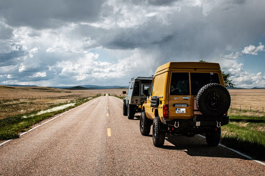 The Landcruisers driving on a dirt road.